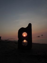 Light painting on beach against sky during sunset