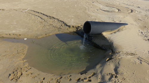 High angle view of water coming out from pipe at beach