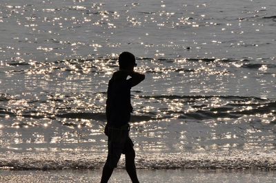 Silhouette woman standing at beach