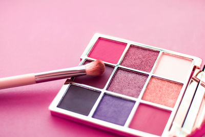 Close-up of beauty products against pink background