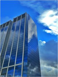 Low angle view of modern building against blue sky