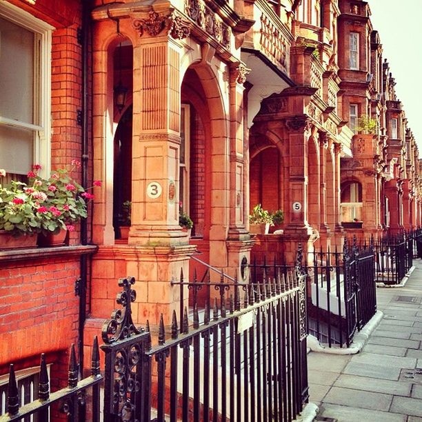 architecture, building exterior, built structure, window, railing, building, arch, human representation, residential structure, door, balcony, residential building, entrance, art and craft, art, house, low angle view, statue, day, facade