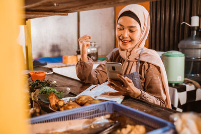 Portrait of young woman preparing food at home