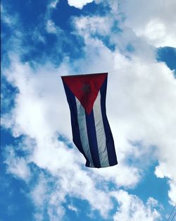 Low angle view of cuban flag against cloudy sky