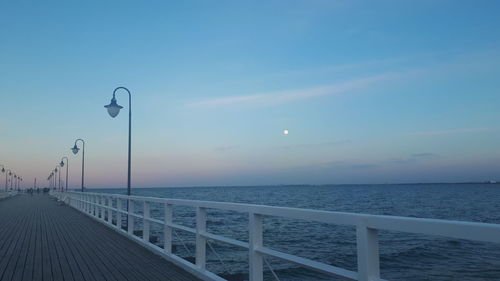 Street by sea against sky at dusk