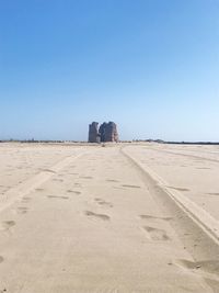 Scenic view of desert against clear blue sky