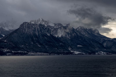 Scenic view of mountains and sea against cloudy sky