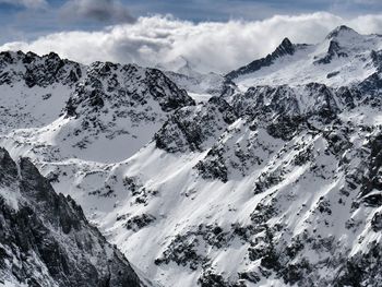 Scenic view of mountains against cloudy sky