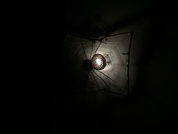 Low angle view of illuminated pendant light in darkroom