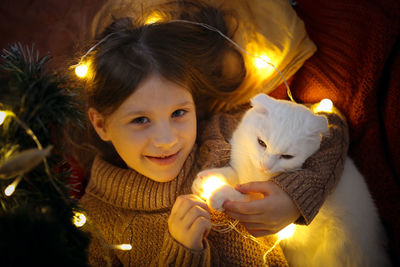 Cat and a girl under the christmas tree in a christmas atmosphere, the concept of christmas