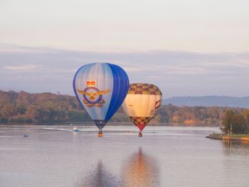 Hot air balloon flying over water against sky