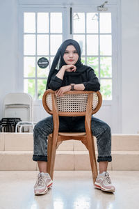 Young woman sitting on sofa at home