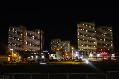 Illuminated cityscape against sky at night