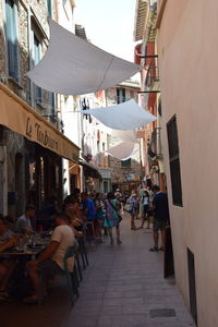 People on street amidst buildings in city