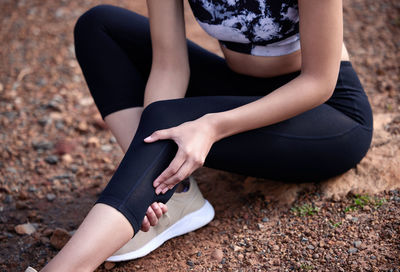 Low section of woman tying shoelace