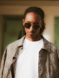 Portrait of young man wearing sunglasses while standing outdoors