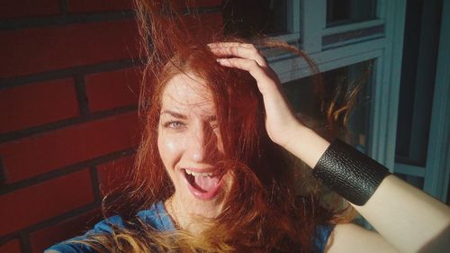 Portrait of cheerful young woman with tousled hair