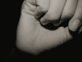 Close-up of hands against black background