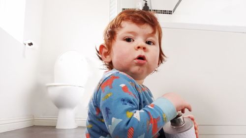 Portrait of cute girl sitting in bathroom