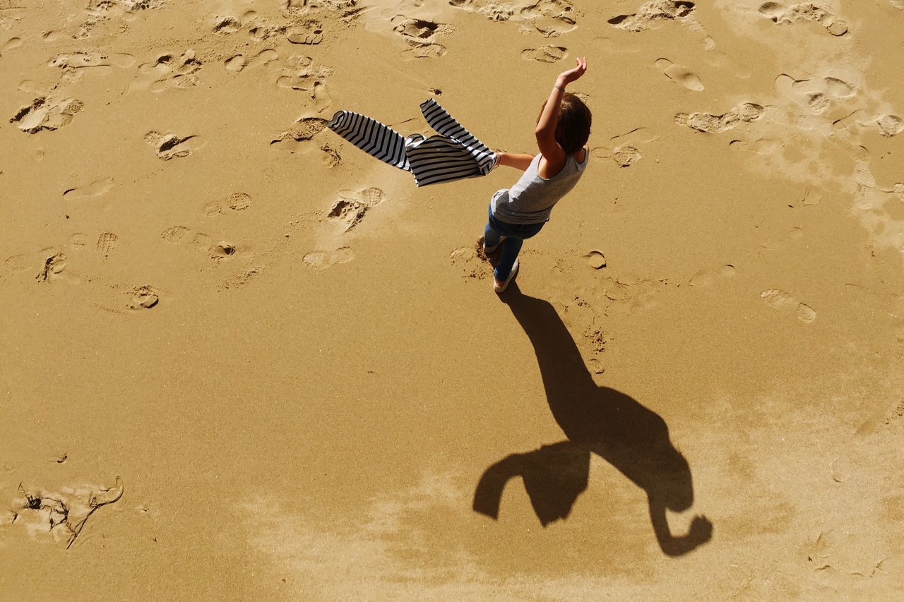 SHADOW OF WOMAN ON SAND