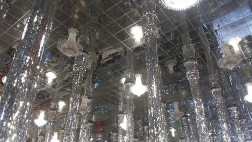 Low angle view of illuminated lights hanging on ceiling in building