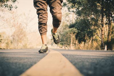 Low section of man running on road