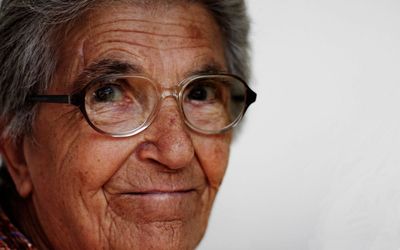 Portrait of senior man wearing eyeglasses against white background