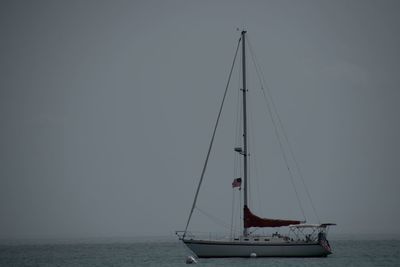 Sailboat sailing on sea against sky