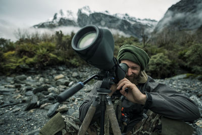 Man looking through monocular