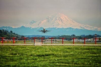 Airplane taking off with mountain in background
