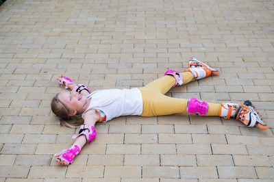 High angle view of woman sitting on footpath