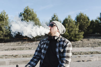 Young man smoking with a electronic cigarette