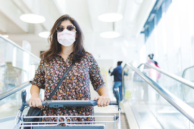 Portrait woman wearing mask standing in supermarket