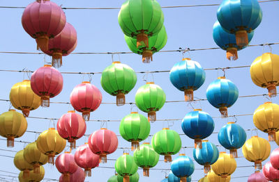 Low angle view of lanterns hanging against sky