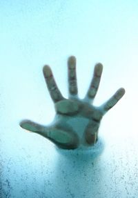 Close-up of human hand on glass window