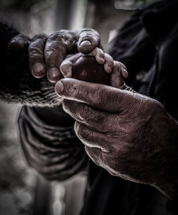 Close-up of man holding hands against blurred background