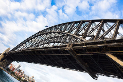 Low angle view of bridge against cloudy sky