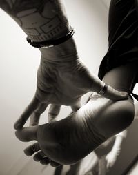 Close-up of man holding hands over white background