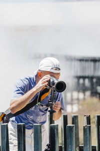 Man photographing outdoors against sky