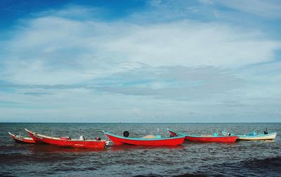 Boats moored in sea against sky