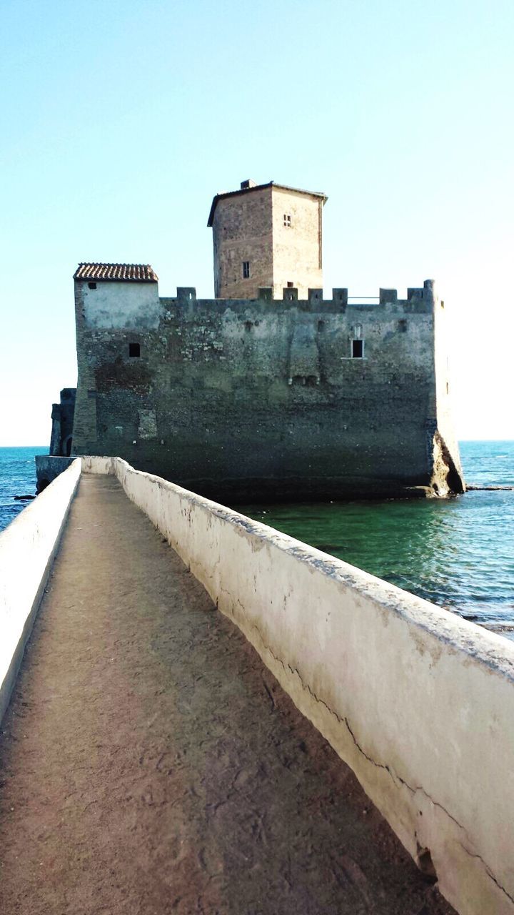 architecture, built structure, building exterior, history, old, clear sky, water, wall - building feature, fortified wall, the past, the way forward, sea, footpath, castle, fort, narrow, outdoors, day, diminishing perspective, medieval, long, stone, no people, local landmark