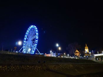 Low angle view of illuminated ferris wheel at night