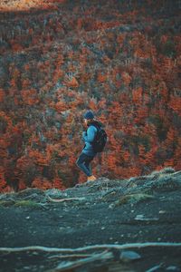 Side view of man standing by tree