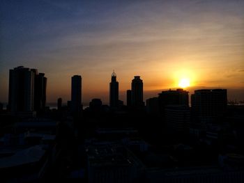 Modern buildings against sky during sunset