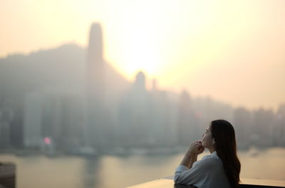 Woman standing against cityscape