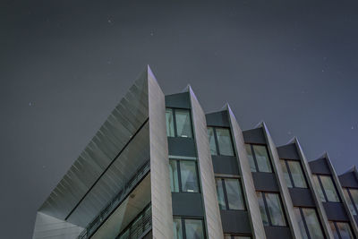 Low angle view of skyscraper against sky at night