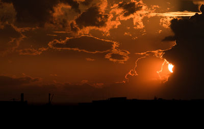 Silhouette landscape against dramatic sky