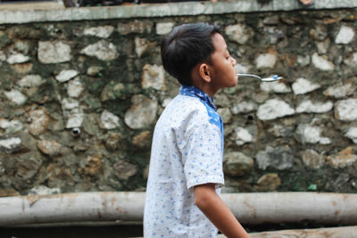 Side view of boy standing outdoors