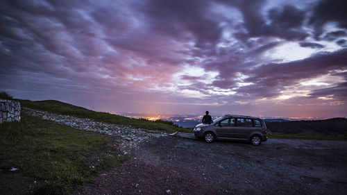 Side view of car against cloudy sky