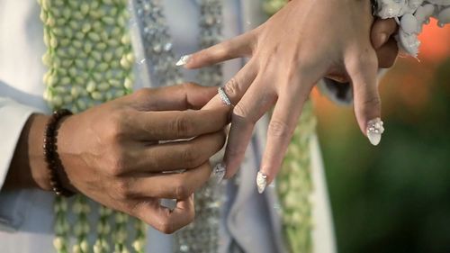 Midsection of couple holding hands